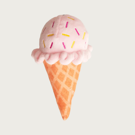 Plush dog toy in the shape of an ice cream cone. Body looks like a waffle cone, ice cream is pale pink with multicolored, embroidered sprinkles.