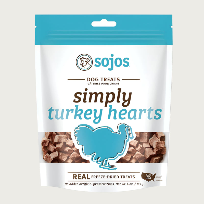 A 4 oz white and teal blue bag of Sojos Simply Turkey Hearts Dog Treats. No added artificial preservatives. See-through window at the bottom of the bag shows product inside - very small, cube shaped brown treats.