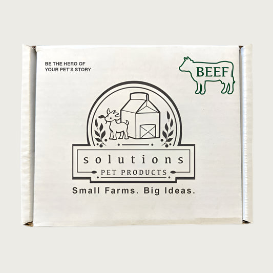 Plain white cardboard box, with text that reads: Be the hero of your pet's story. Center logo says Solutions Pet Products, Small Farms. Big Ideas. Outline of a cow in the top right corner, with BEEF written inside it.