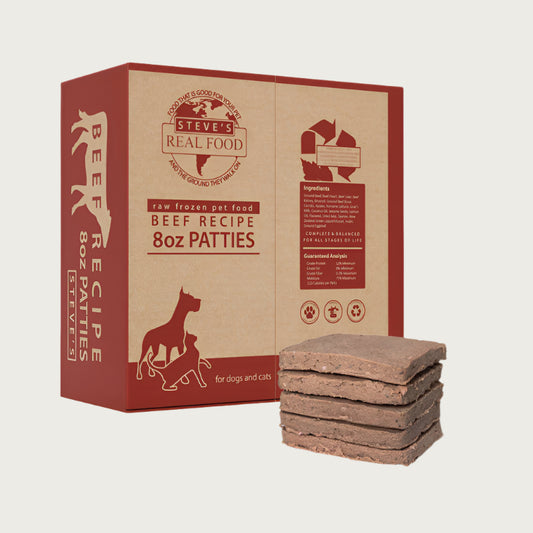 A 14 pound box of Steve's Real Food frozen raw food 8 ounce patties in the beef recipe for both dogs and cats. A plate of the bar shaped patties is positioned in front of the box for reference.