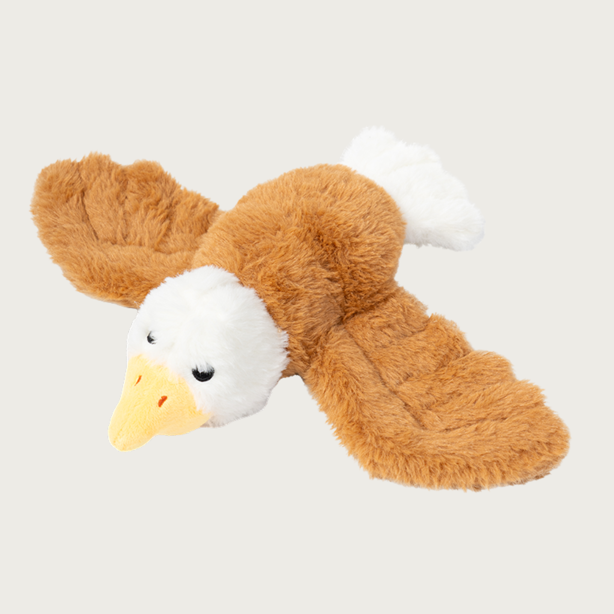 Plush flying bald eagle dog toy, with brown fluffy wings and body, white head & tail, yellow beak, and black embroidered eyes.