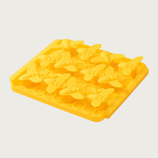 Photo of the Tall Tails Foraging Mat in Busy Bee design. It is bright yellow, square, with three tightly packed rows of raised, bee shapes, each about 1"-2" wide.