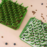 Image of two of the Grass style Foraging Mats, side by side. One has kibbles in the bottom and the other has a mix of kibbles, blueberries and goat milk.