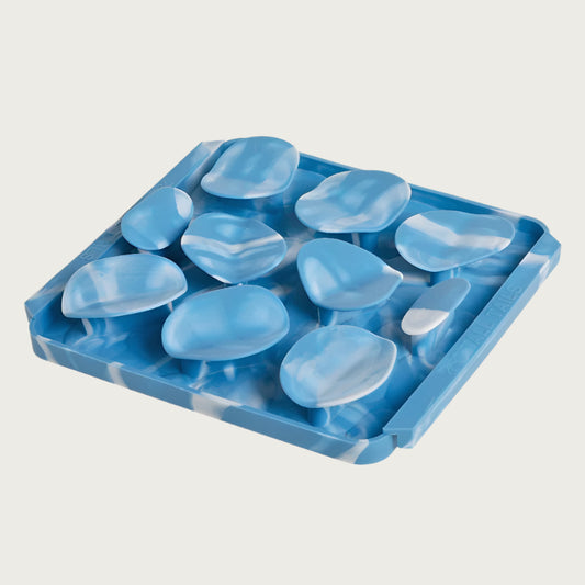 Photo of the Tall Tails Foraging Mat in Rock design. It is sky blue marbled with white, square, with three rows of raised, irregular circles, each about 2" wide.
