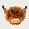 A plush ball in the shape of a highland cow's head. It has embroidered eyes, tan snout, and gray horns. Covered in caramel colored shaggy plush fabric.