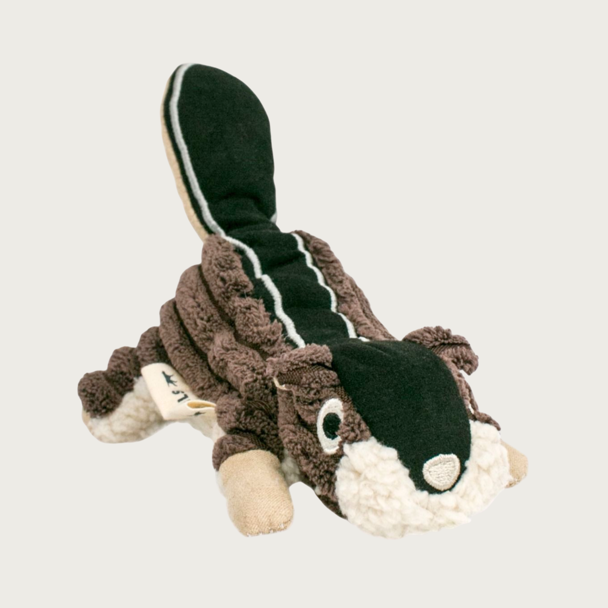 Plush dog toy shaped like a chipmunk on its belly. Its body is dark brown, wide-wale thick plush, with a wide black stripe running from it's head to tail. Embroidered facial features.
