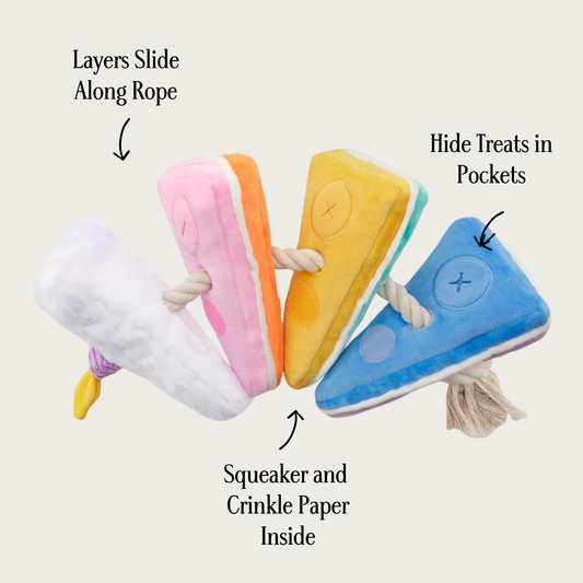 Side, more open view of the Birthday Cake Interactive Snuffle toy, showing rope between layers, with text descriptors. With arrows pointing to the toy in different locations, text reads "squeaker and crinkle paper inside" and "hide treats in pockets" and "layers slide along rope."