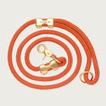 Load image into Gallery viewer, Coiled, burnt orange colored rope dog leash with brass hardware. Fastened on both ends with brass clamps, instead of stitching. O-ring is in the handle part of the leash, with lobster claw style of clasp to connect to collar or harness.
