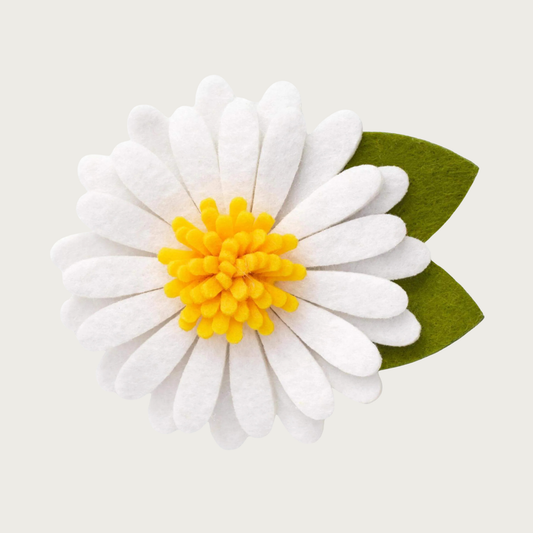 Layered white felt daisy dog collar flower with long petals, yellow center, and dark green felt leaves.