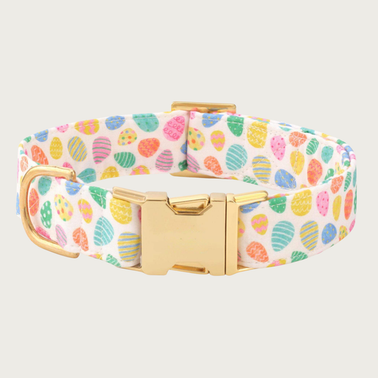 Dog collar featuring a pastel multi-colored Easter egg print on cream background with gold hardware.