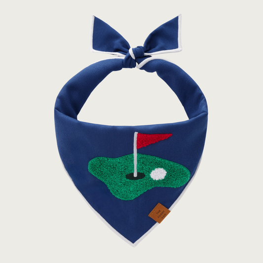 Navy blue dog bandana, with a chenille applique of a golf scene (patch of green with a hole, and red flag sticking out, with a white ball next to the hole).