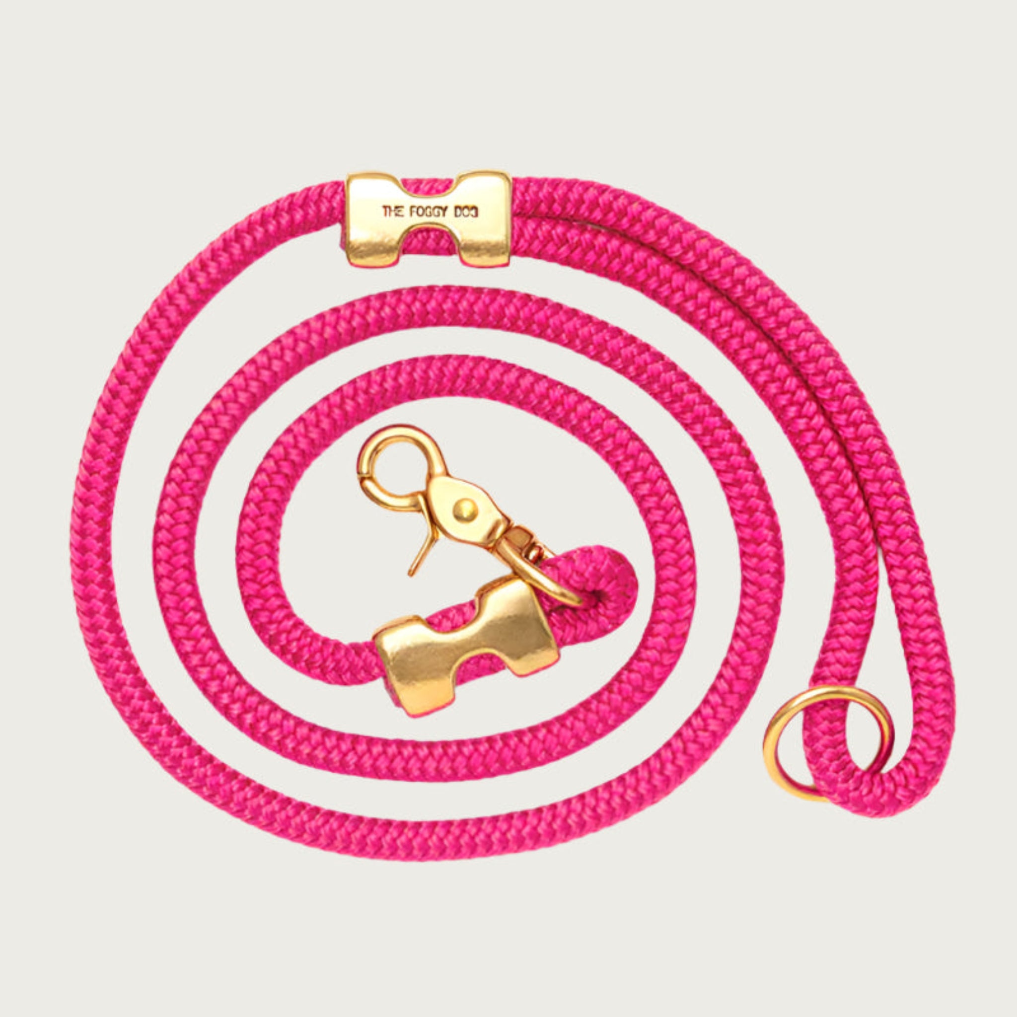 Coiled, hot pink rope dog leash with brass hardware. Fastened on both ends with brass clamps, instead of stitching. O-ring is in the handle part of the leash, with lobster claw style of clasp to connect to collar or harness.