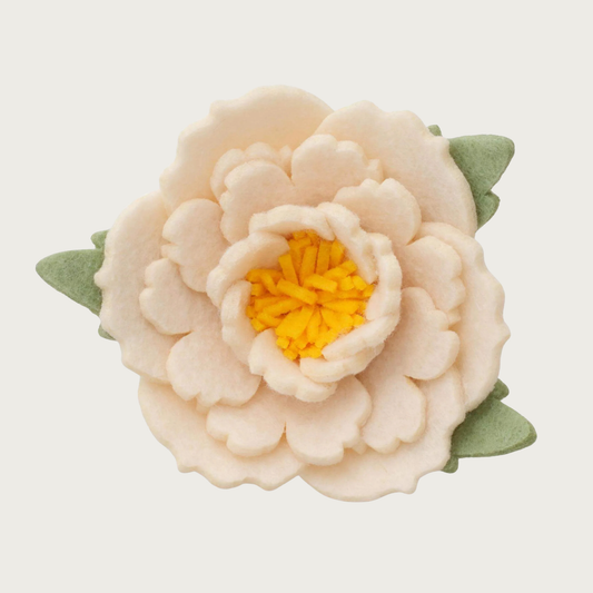 Layered ivory felt peony dog collar flower with rounded, scalloped edges, with yellow center, and light green felt leaves.
