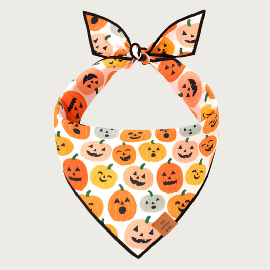Halloween-themed dog bandana with jack o' lanterns in various shapes & colors, with different expressions, on a white background.