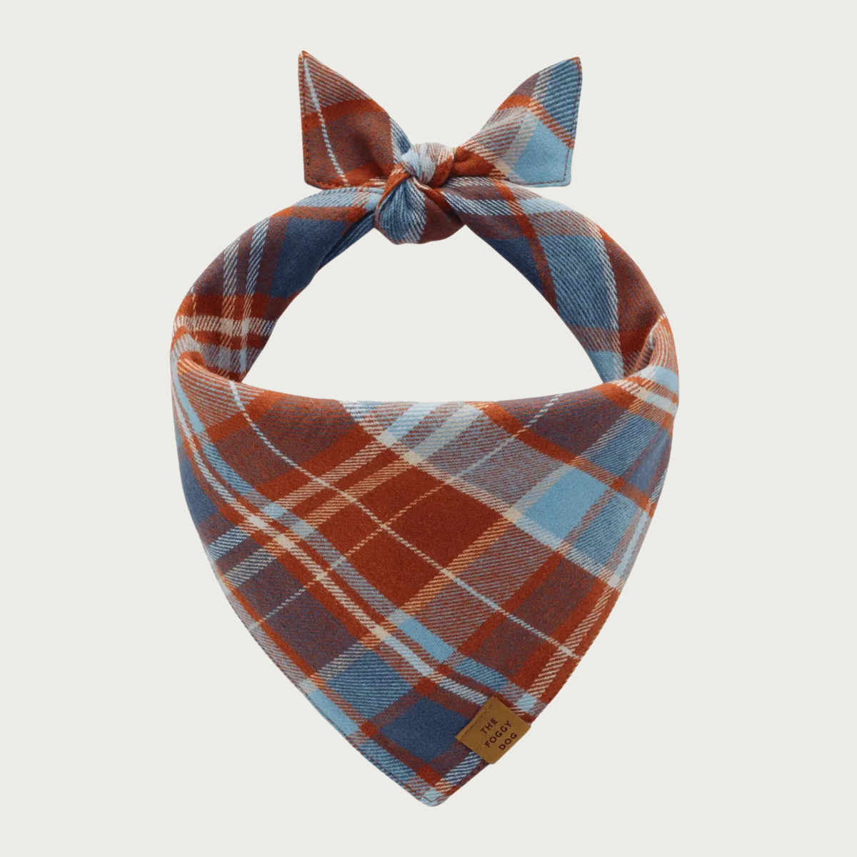 A flannel dog bandana tied at the top, featuring a plaid pattern of rust brown, dusty blue, and cream.