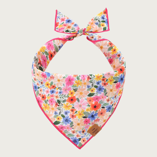 Dog bandana with a colorful, watercolor-style wildflower print and hot pink edging.