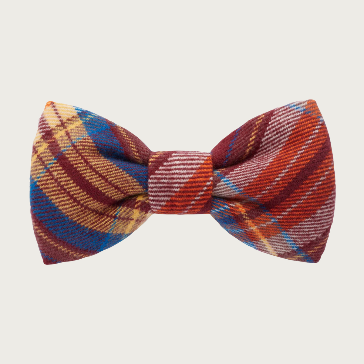 A flannel dog bow tie, featuring a plaid pattern of rust, gold, and medium blue.