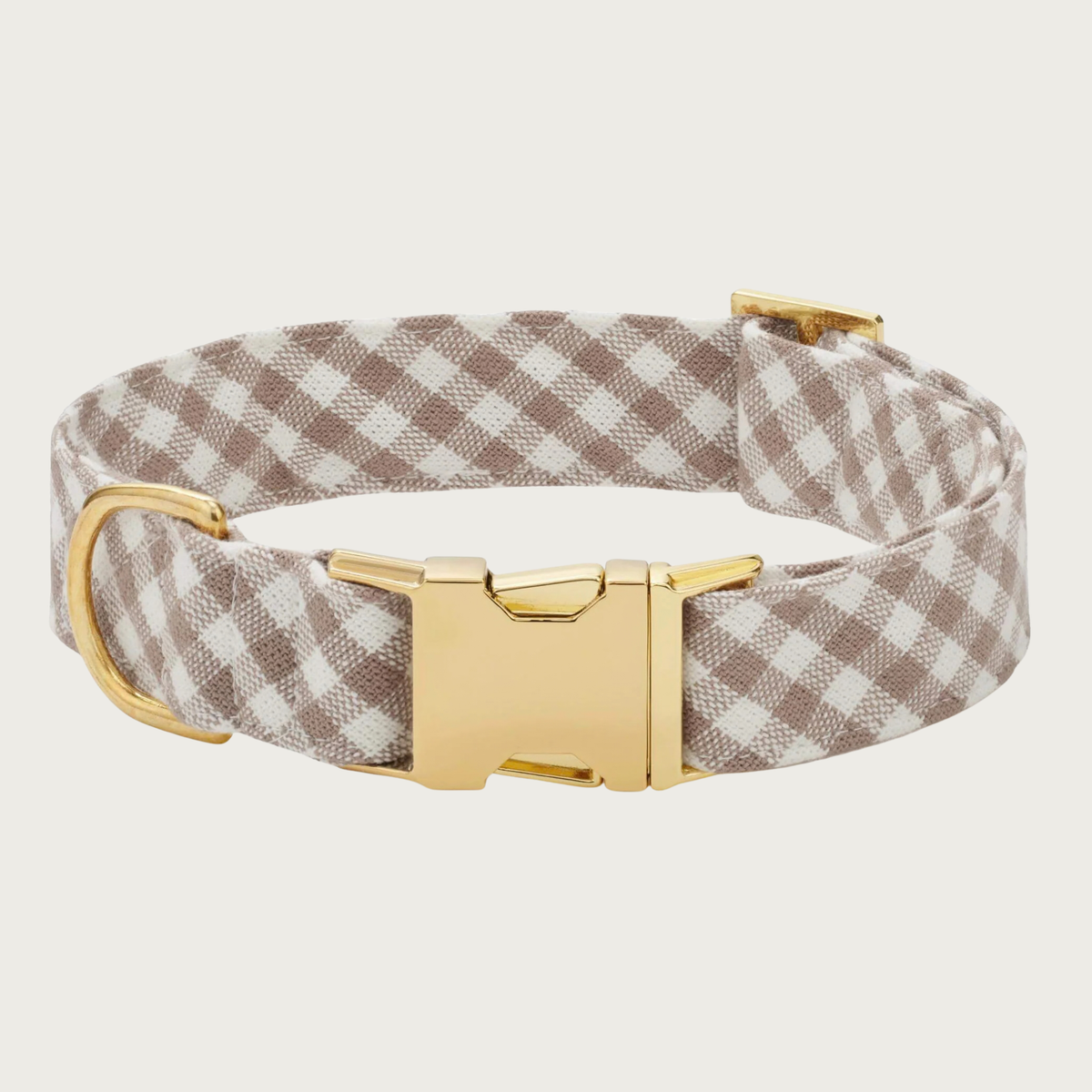 A dog collar with a light taupe-brown and white gingham check pattern and polished gold-tone metal buckle & hardware.