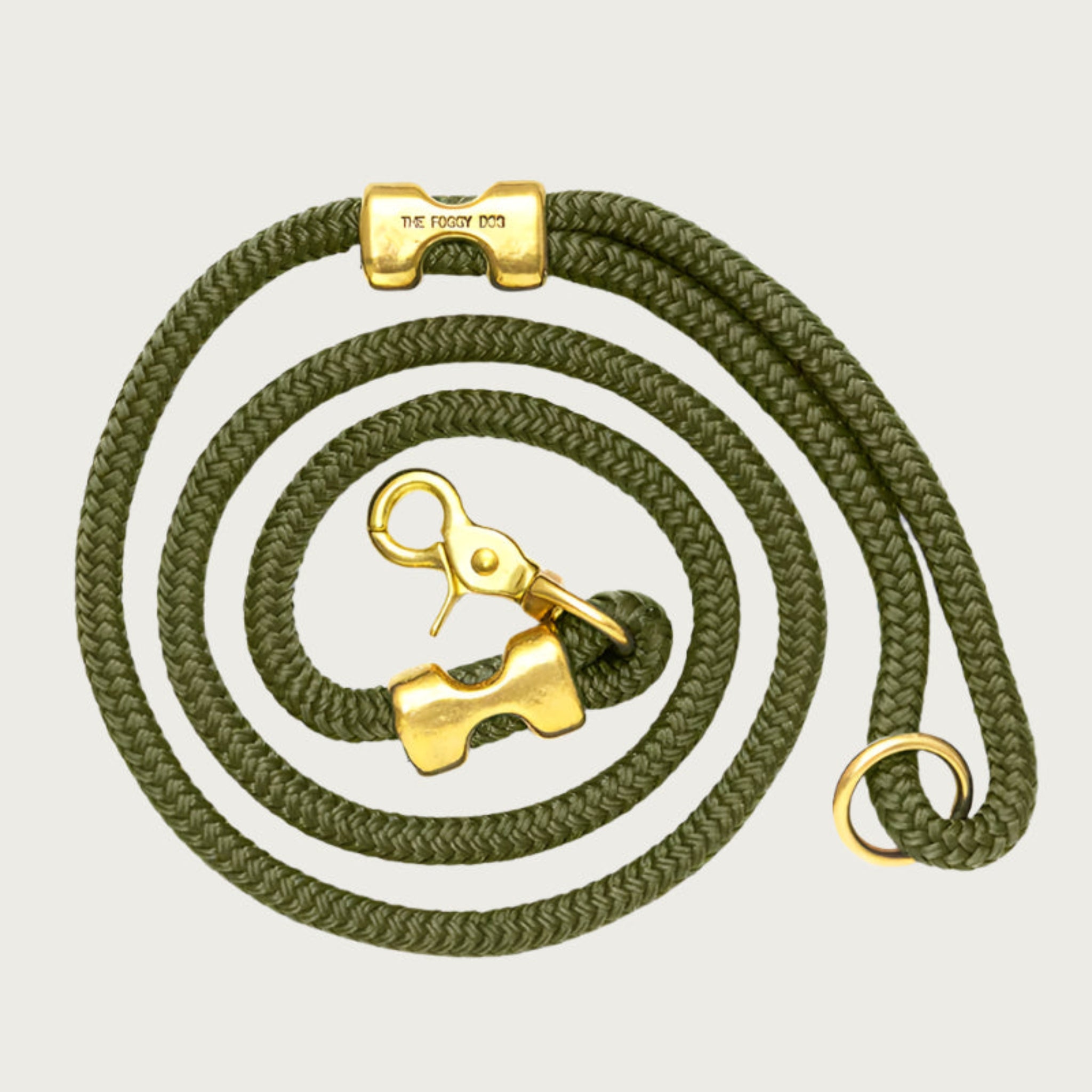 Coiled, olive green rope dog leash with brass hardware. Fastened on both ends with brass clamps, instead of stitching. O-ring is in the handle part of the leash, with lobster claw style of clasp to connect to collar or harness.