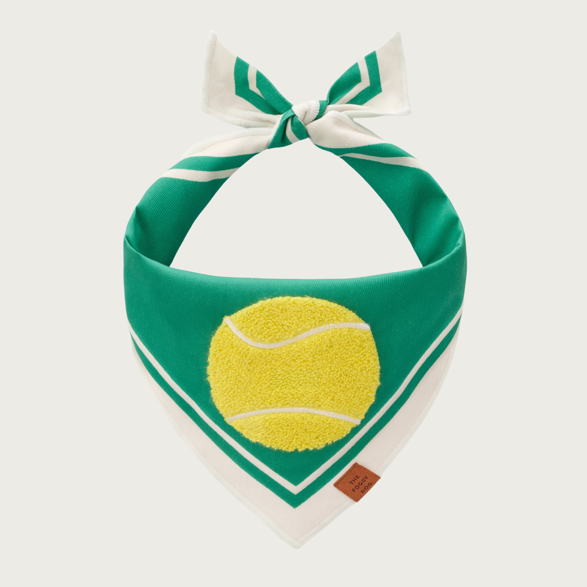 Green dog bandana with white trim on its edges, with a bright yellow chenille applique tennis ball in the center.
