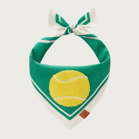 Green dog bandana with white trim on its edges, with a bright yellow chenille applique tennis ball in the center.