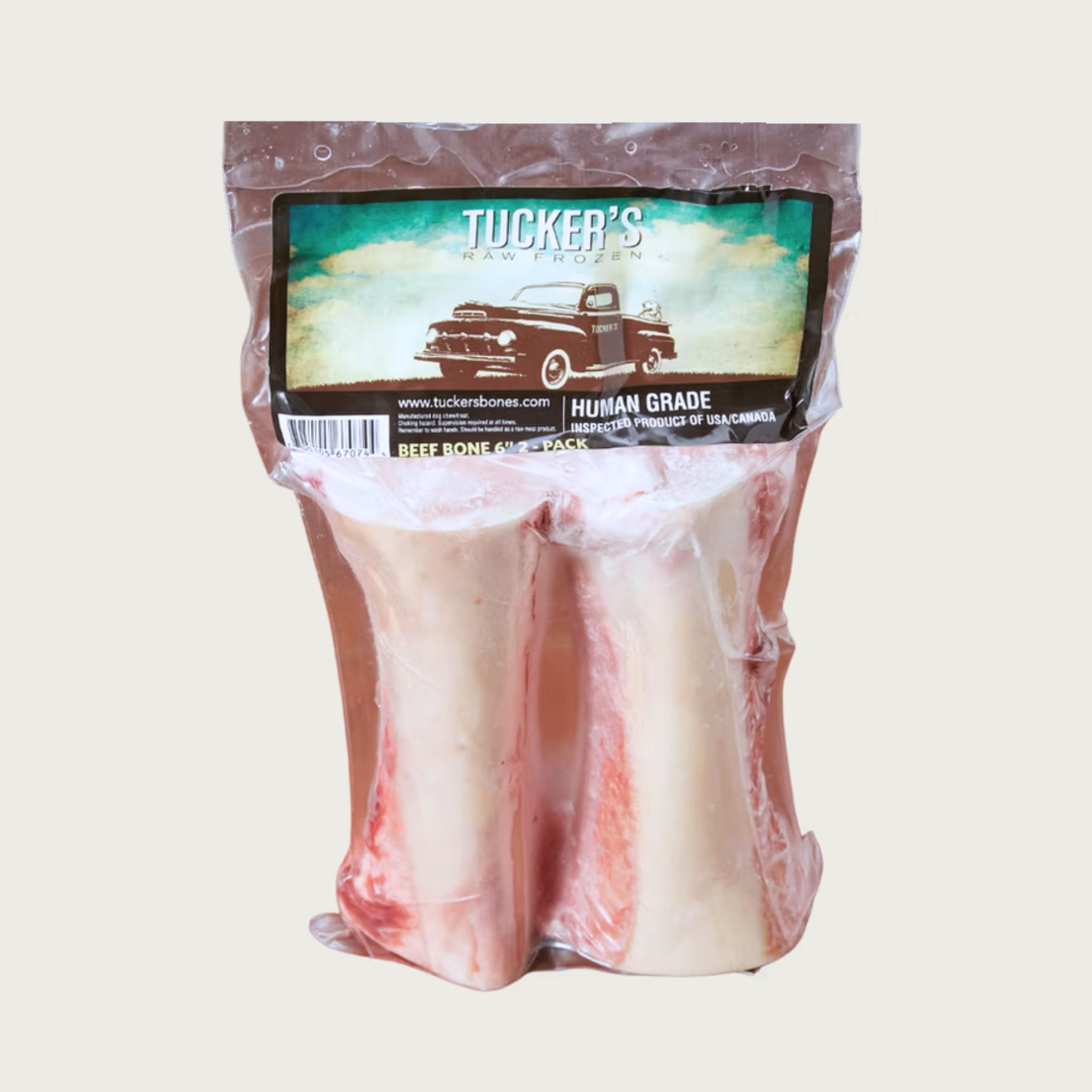 Shrink wrapped package of 2 - 6" beef marrow bones from Tucker's. Bones are visible, and have meat attached. 