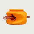 Load image into Gallery viewer, An orange rubber dog toy shown with a bully chew stick inserted horizontally through its indented center.

