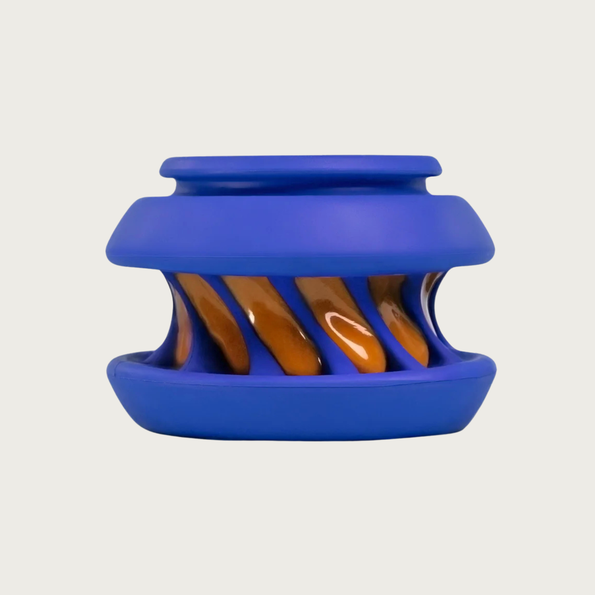 A blue rubber dog toy with an indented, twisted center with ridges, that is smeared with peanut butter.