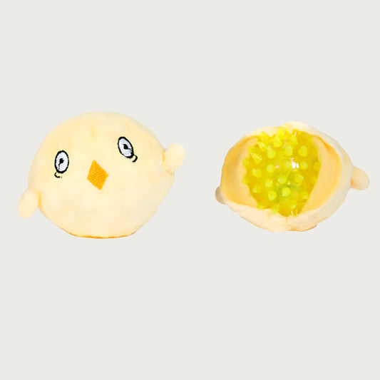 Small, pale yellow chick toy that has been opened up to show the yellow, spiky rubber ball inside it. This toy is what's inside the larger chicken.