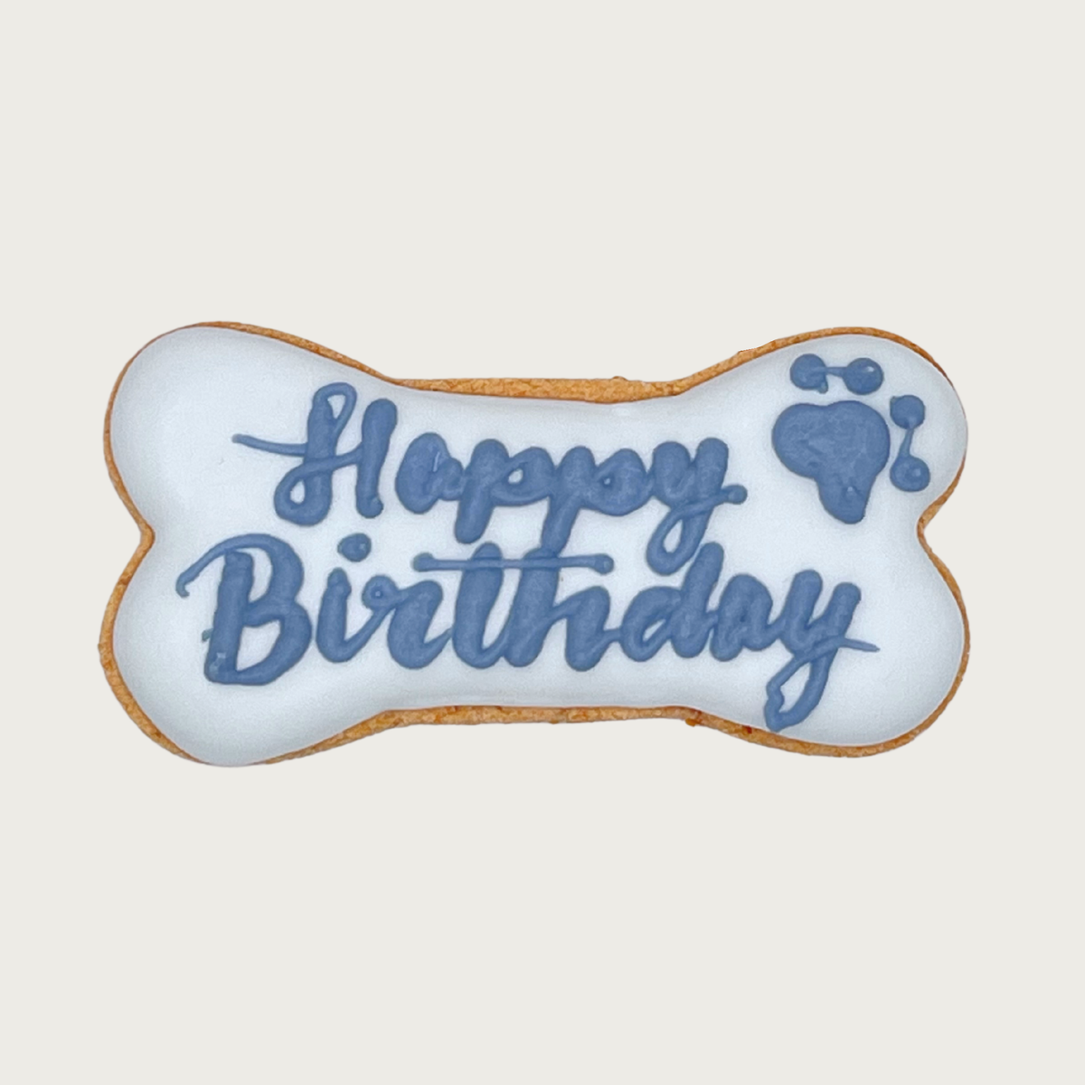 Bone-shaped dog cookie with pale blue icing. "Happy Birthday" is handwritten in script, in medium blue, with a medium blue paw print in the top right corner.