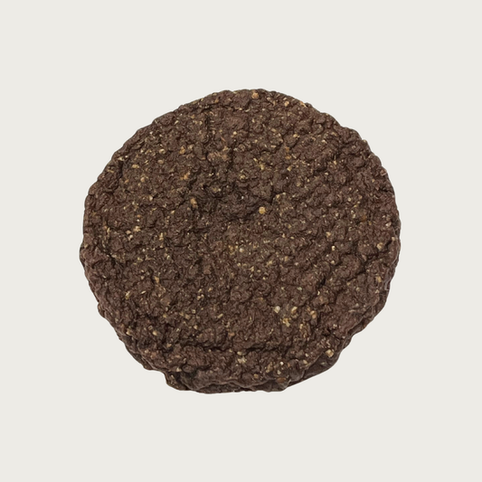 Round, textured, dark brown Beef Burger dog treat.