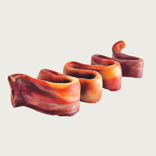 Reddish-brown dog chew shaped like a tightly condensed squiggle. The shape is reminiscent of hard ribbon candy.