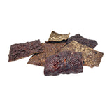 Close-up of a small pile of Wet Nose Beef Crispies treats. They are dark brown, thin squares about 2.5" wide, with a bumpy texture.