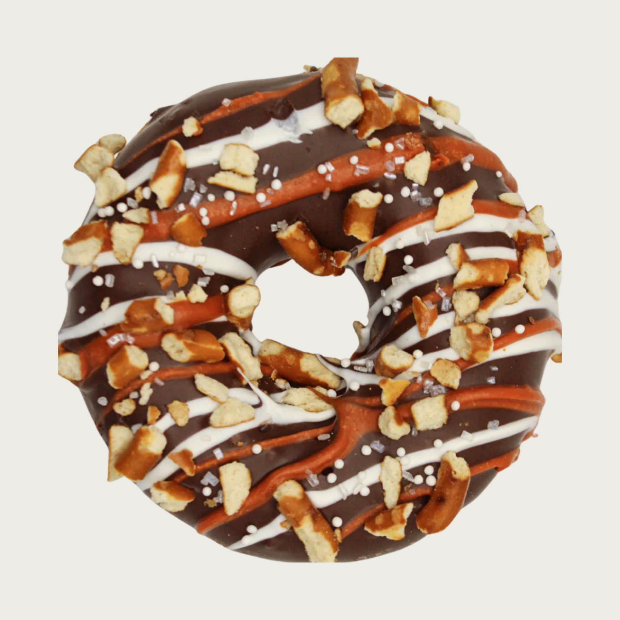 Donut-shaped dog cookie dipped in carob, drizzled with white & tan icing, and decorated with chopped pretzel pieces.