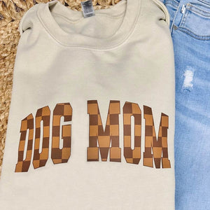 Light beige sweatshirt with "Dog Mom" in varsity style block text, with brown & tan checkerboard pattern.