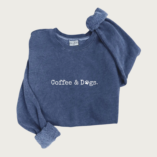 Heathered navy blue crewneck sweatshirt with centered 'Coffee & Dogs' text in white typewriter-style font. The "o" in Dogs is a paw print.