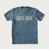 Medium shade of Indigo blue crew neck t-shirt with "Dog Dad" on chest in large, all caps, distressed white text.