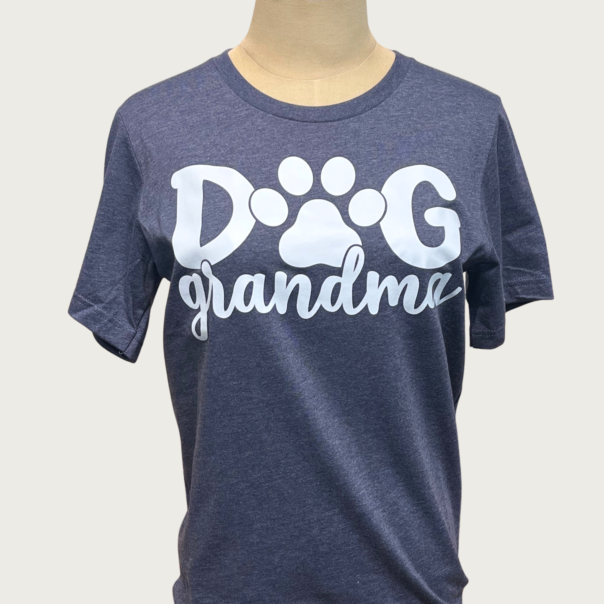 Heathered navy blue t-shirt on a mannequin with white 'Dog Grandma' text in center. "DOG" is in large print with a paw print instead of the "o", "grandma" is beneath in script text.