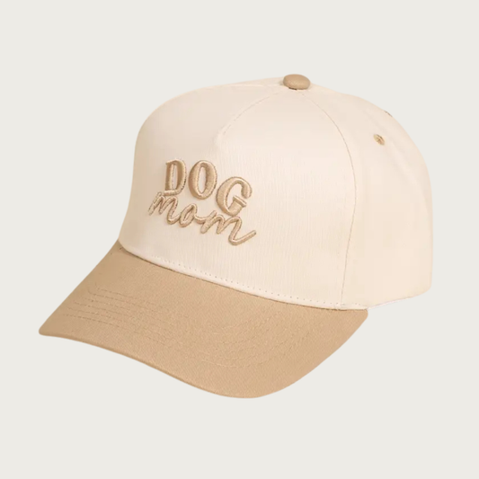 Two-toned baseball cap with ivory body and tan bill & button on top. The cap reads "DOG mom" in embroidered tan text-"DOG" is in all caps, and "mom" is in lower case script text.