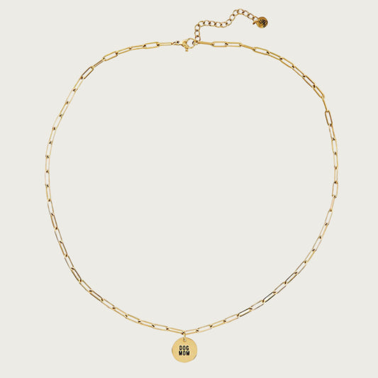 Gold-toned chain link necklace with a small, round gold-toned pendant that reads "Dog Mom" in black.