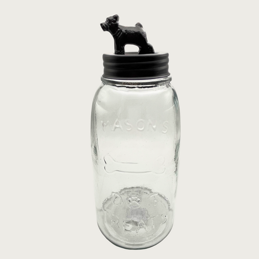 Clear glass mason style treat jar with dark bronzed metal lid. Lid has a 3D figure on top that's about 2.5" tall, and resembles a bulldog-type dog.