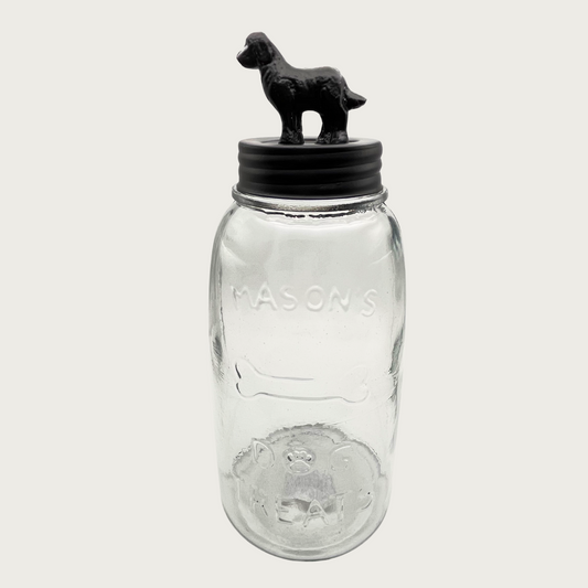 Clear glass mason style treat jar with dark bronzed metal lid. Lid has a 3D figure on top that's about 2.5" tall, and resembles a golden retriever-type dog.
