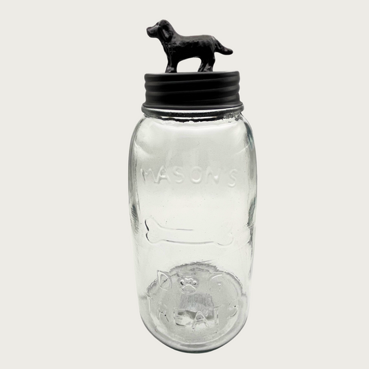 Clear glass mason style treat jar with dark bronzed metal lid. Lid has a 3D figure on top that's about 2.5" tall, and resembles a labrador retriever-type dog.
