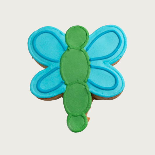Simple dog cookie shaped like a dragonfly with bright blue wings and green body.