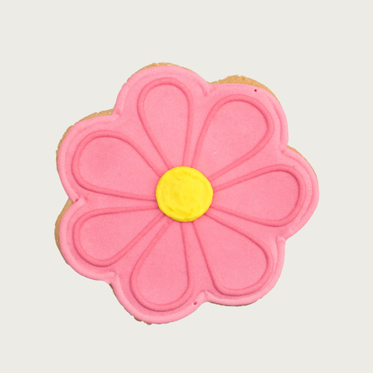 Bubblegum Pink daisy-shaped dog cookie with a round yellow center.