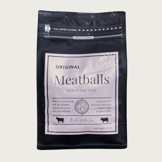 A 12 oz black bag of Original Meatballs treats for dogs and cats. Made with Love in the Wet Nose Kitchen. Features grass fed beef, hormone free pork, organic eggs and organic herbs.