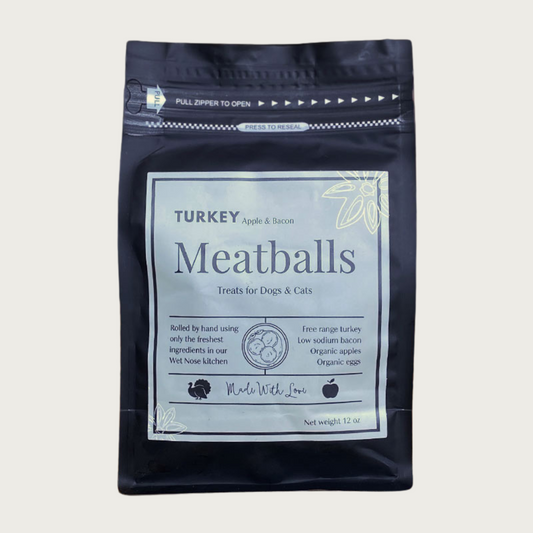 A 12 oz black bag of Turkey, Bacon and Apple Meatballs treats for dogs and cats. Made with Love in the Wet Nose Kitchen. Features free range turkey, low sodium bacon, organic apples, and organic eggs.