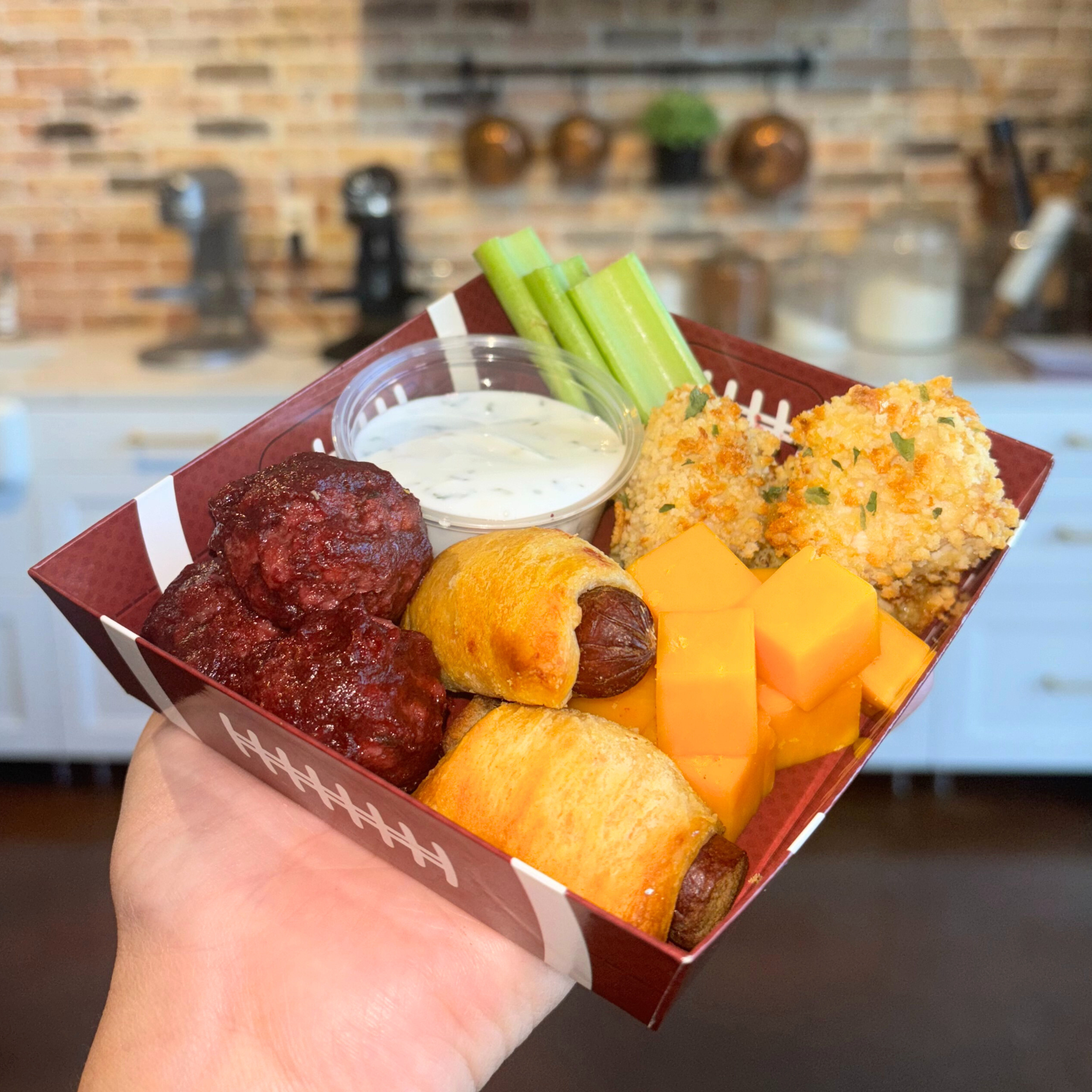 Football-themed, square snack tray with various bite-sized dog-safe finger foods.