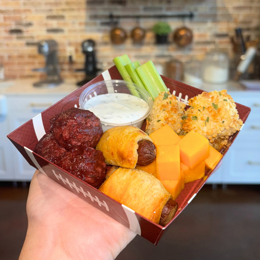 Football-themed, square snack tray with various bite-sized dog-safe finger foods.