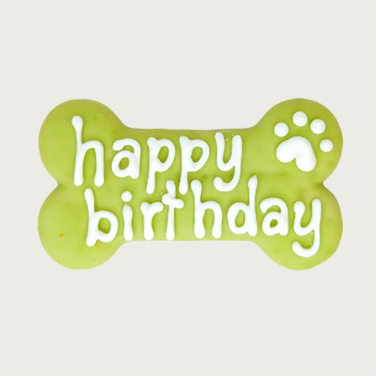 Lime green bone-shaped dog cookie with 'happy birthday' text in white, with white paw print accent.